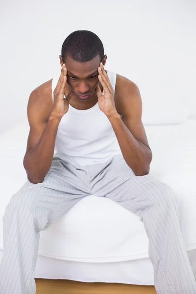 Düşünceli afro adam yatakta oturuyor — Stok fotoğraf