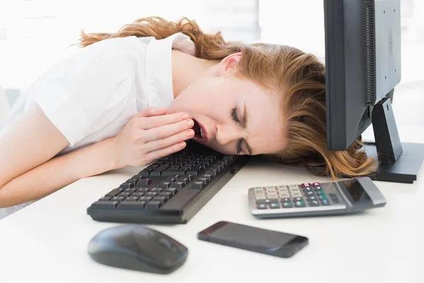 Businesswoman resting head on keyboard at office — Stock Photo, Image