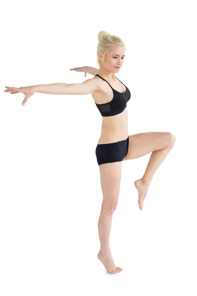 Deportiva mujer balanceándose en una pierna mientras estira las manos —  Fotos de Stock