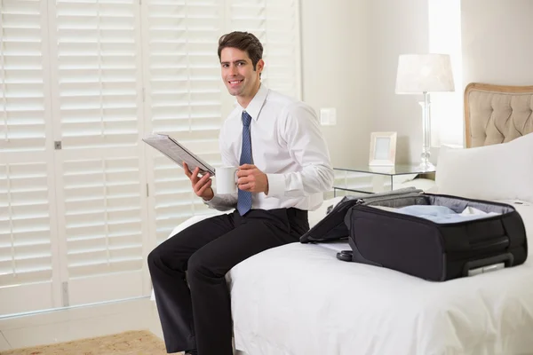 Homme d'affaires avec tasse à café et journal par bagage à la chambre d'hôtel — Photo