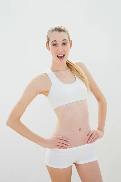 Linda mujer deportiva posando con las manos en las caderas usando ropa deportiva — Foto de Stock