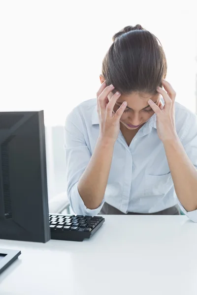 Mujer de negocios que sufre de dolor de cabeza delante de la computadora —  Fotos de Stock