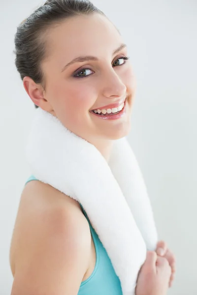 Fit woman with towel around neck against wall — Stock Photo, Image