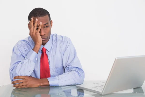 Wütender Afro-Geschäftsmann mit der Hand im Gesicht am Schreibtisch — Stockfoto