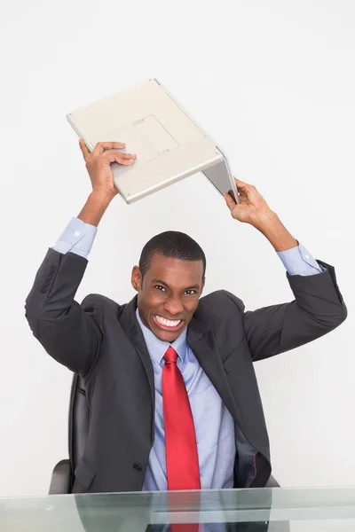 Frustrierter Afro-Geschäftsmann zertrümmert Laptop auf Schreibtisch — Stockfoto