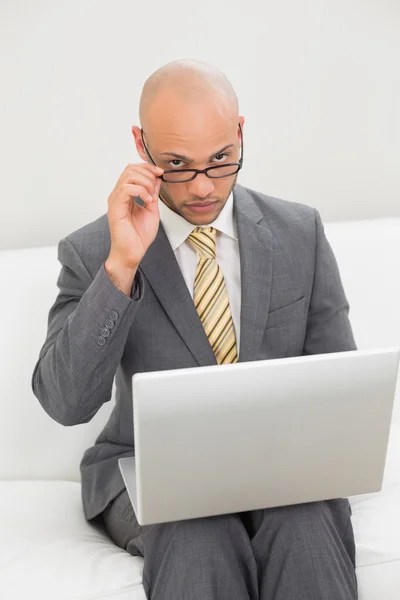 Zakenman met behulp van laptop op de Bank thuis — Stockfoto