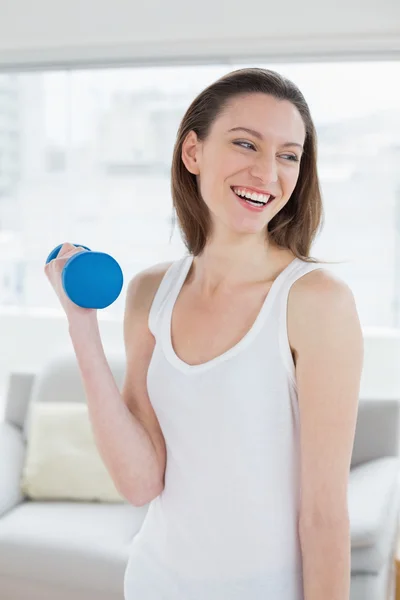 Ajuste de mujer joven haciendo ejercicio con la mancuerna en el estudio de fitness brillante —  Fotos de Stock