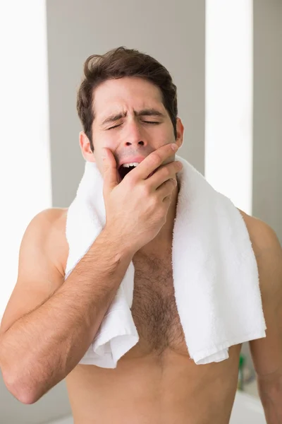 Hombre sin camisa bostezando con los ojos cerrados en casa —  Fotos de Stock