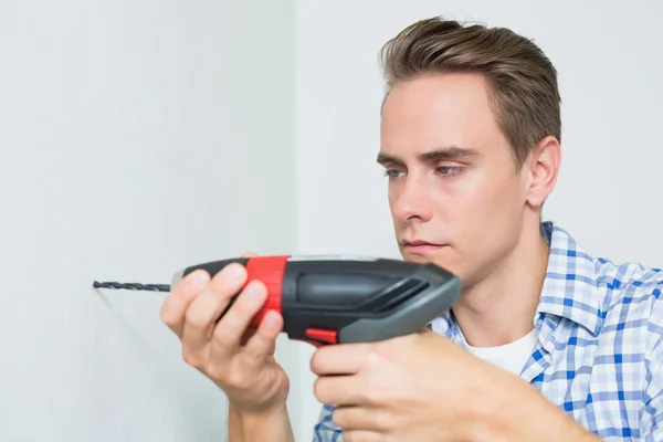 Handyman using a cordless drill to the wall — Stock Photo, Image