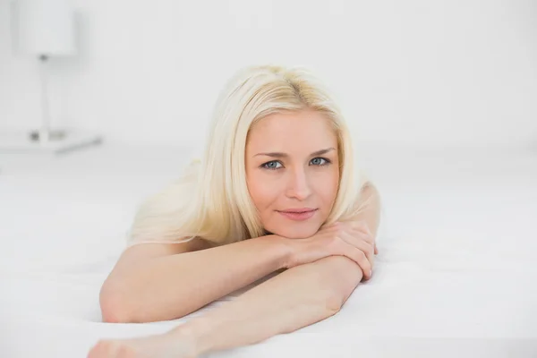 Close up van een glimlachende mooie blonde in bed — Stockfoto