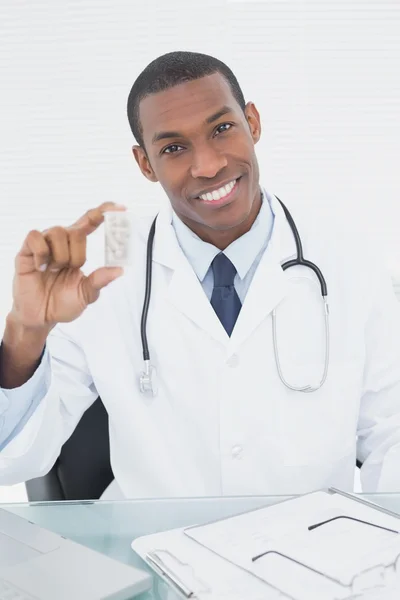 Médico sério que escreve uma receita no consultório médico — Fotografia de Stock