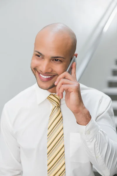 Empresário sorridente usando celular no escritório — Fotografia de Stock