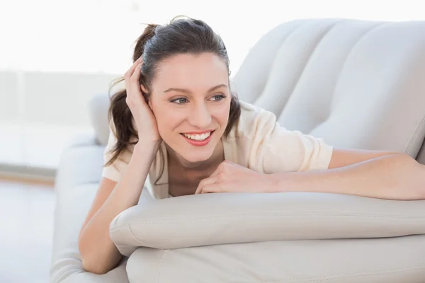 Sonriendo relajada mujer casual acostada en el sofá — Foto de Stock