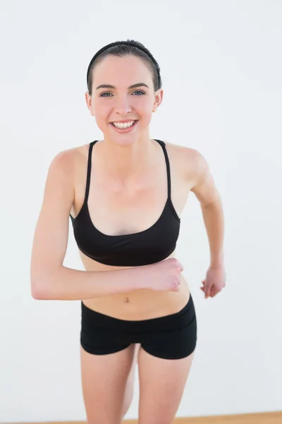 Sorridente giovane donna tonica fianchi in palestra — Foto Stock