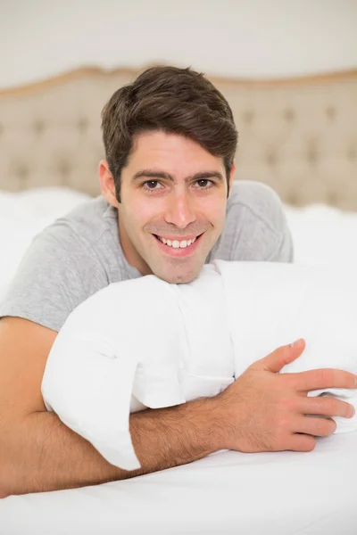 Yatakta dinleniyor gülümseyen bir adam portresi yukarıya kapatmak — Stok fotoğraf