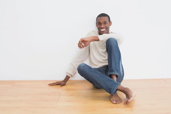 カジュアルなアフロ若い男が壁に座っています。 — ストック写真
