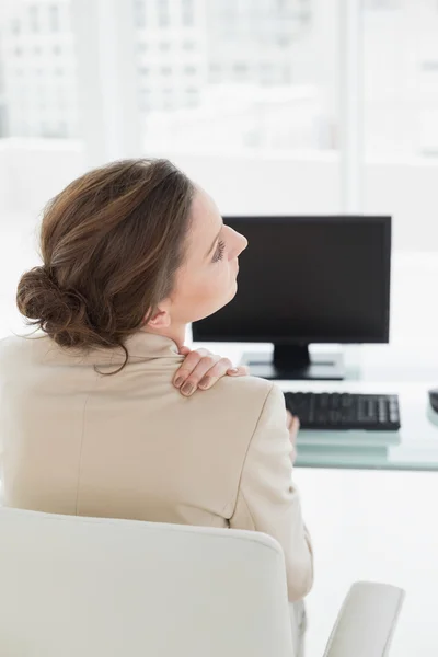 Affärskvinna med nacksmärta framför datorn i office — Stockfoto