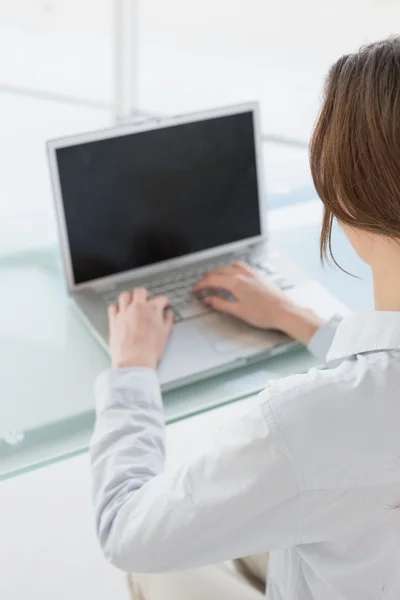 Portrait of smiling brown haired businesswoman using laptop — Stock Photo, Image