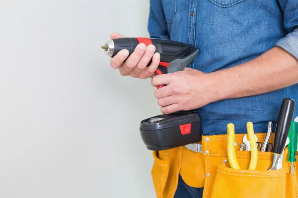 Partie médiane d'un homme à tout faire avec perceuse et ceinture à outils — Photo