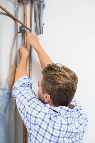 Techniker, der die Rohre eines Warmwasserbereiters wartet — Stockfoto