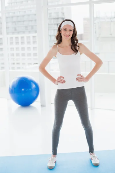 Tonas kvinna med händerna på höfterna står i fitness-studio — Stockfoto