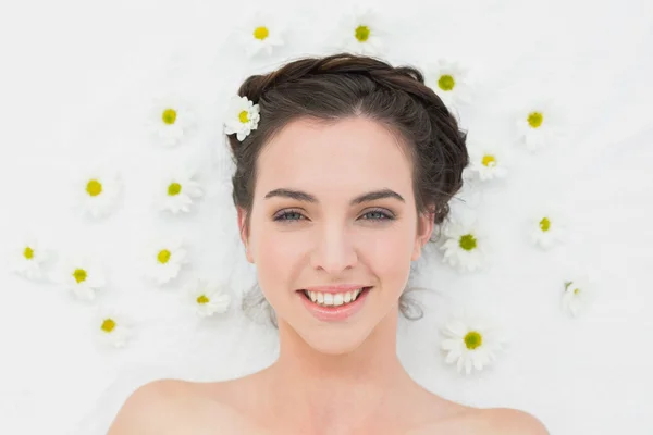 Schöne junge Frau mit Blumen im Schönheitssalon — Stockfoto