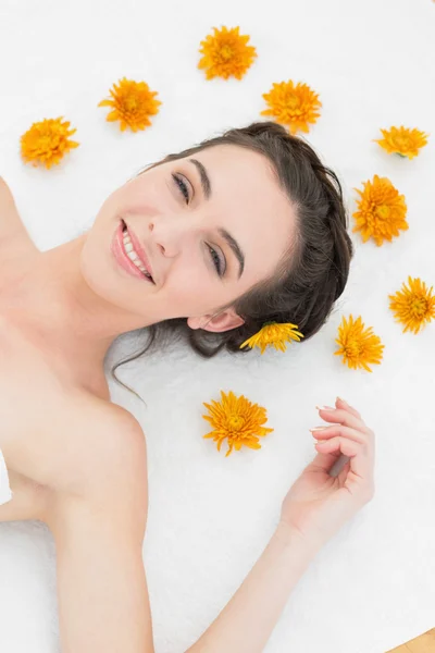 Piękna młoda kobieta z kwiatami w gabinecie kosmetycznym — Zdjęcie stockowe