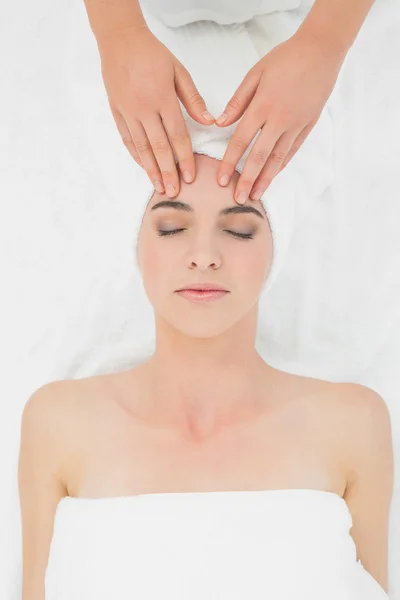 Mãos a massajar a testa de uma bela mulher no spa de beleza — Fotografia de Stock