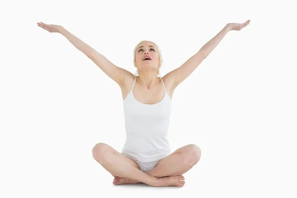 Toned young woman sitting with arms outstretched — Stock Photo, Image