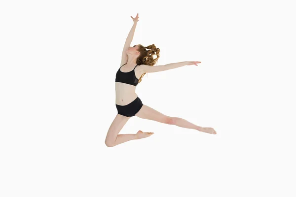 Full length side view of a sporty woman jumping — Stock Photo, Image