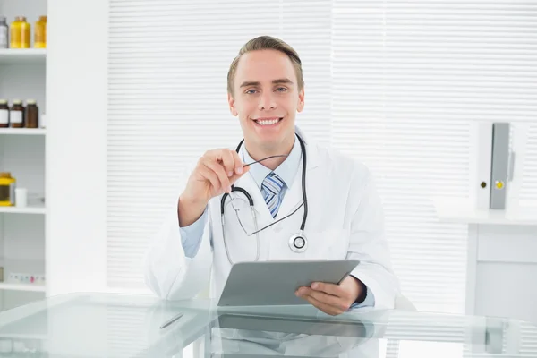 Sorridente medico di sesso maschile guardando tablet digitale — Foto Stock