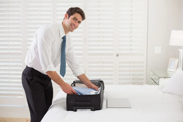 Bagage bij een hotel slaapkamer uitpakken zakenman — Stockfoto