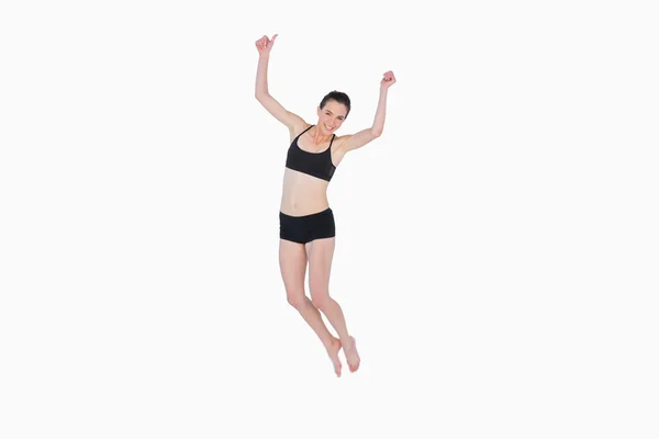 Toute la longueur d'une jeune femme sportive sautant — Photo