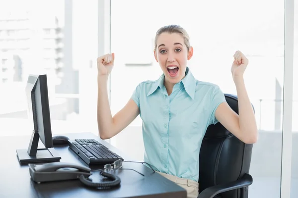 Classy businesswoman cheering sitting at her desk — Stock Photo, Image