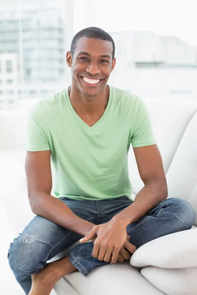 Sorridente rilassato uomo afro seduto sul divano — Foto Stock