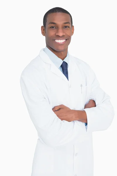 Smiling male doctor standing with arms crossed Stock Image