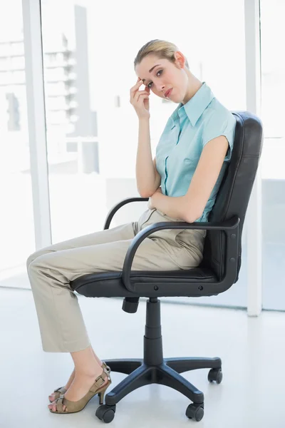 Exhausted classy businesswoman sitting on her swivel chair Stock Photo