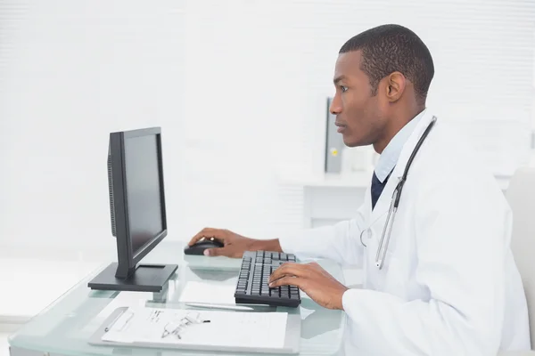 Concentrated doctor using computer at medical office — Stock Photo, Image