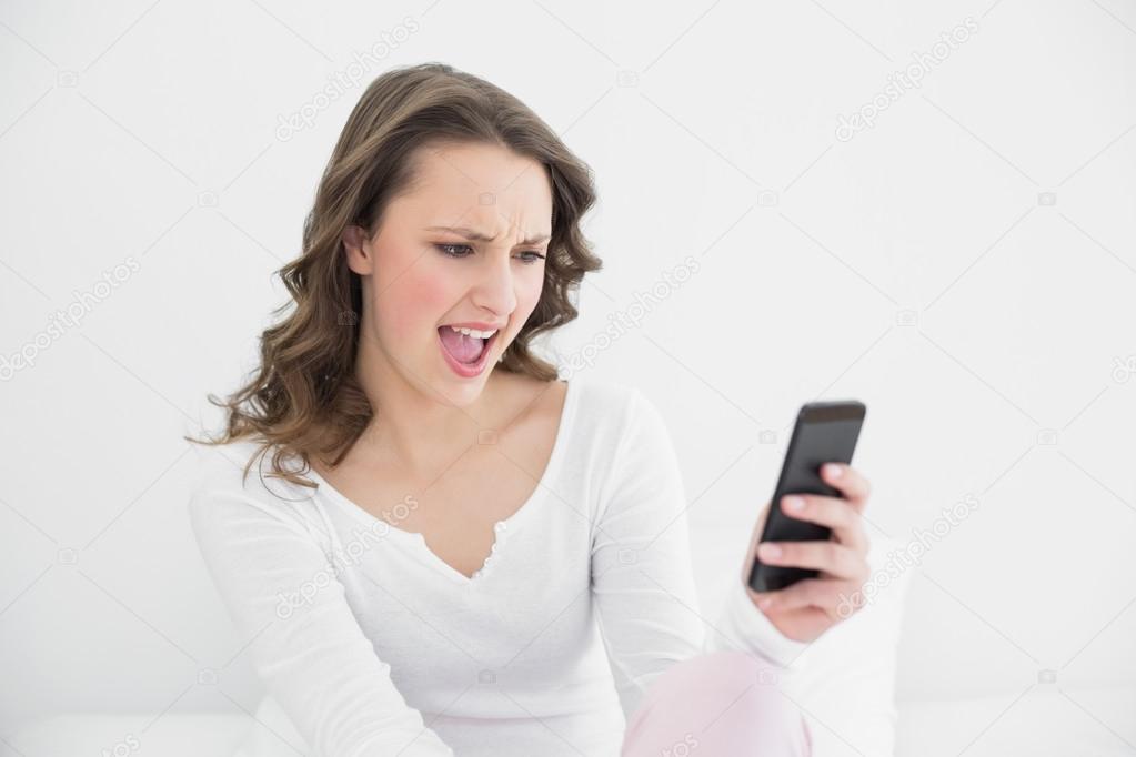 Shocked woman looking at mobile phone