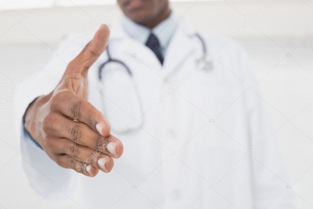 Mid section of male doctor offering a handshake