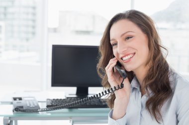 Telefonunuzun ve bilgisayar önünde işkadını gülümseyen