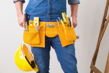 bir tamirciyle toolbelt ve kask ile orta kısmında