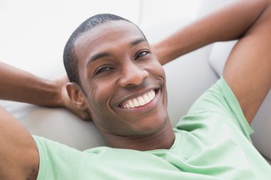 gülümseyen rahatlamış afro adam kanepede yatan, yakın çekim