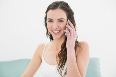 neşeli rahat kadın yatakta istimal hareket eden telefon