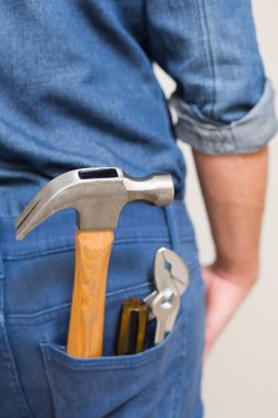Several tools in a man's rear denim pocket