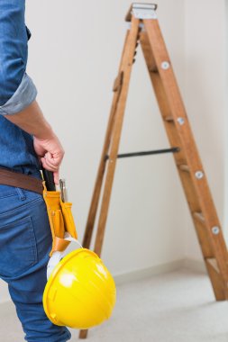 bir tamirciyle toolbelt ve kask ile orta kısmında