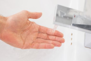 banyo lavabo akan suyun altında el