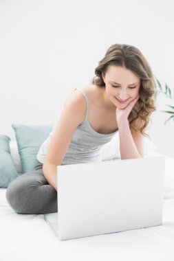 laptop yatakta Casual esmer bakarak gülen