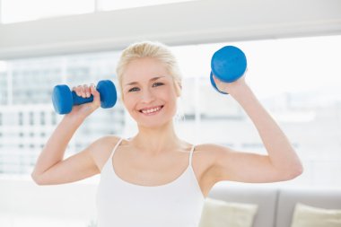 gülümseyen kadın fitness stüdyosu dumbbells ile