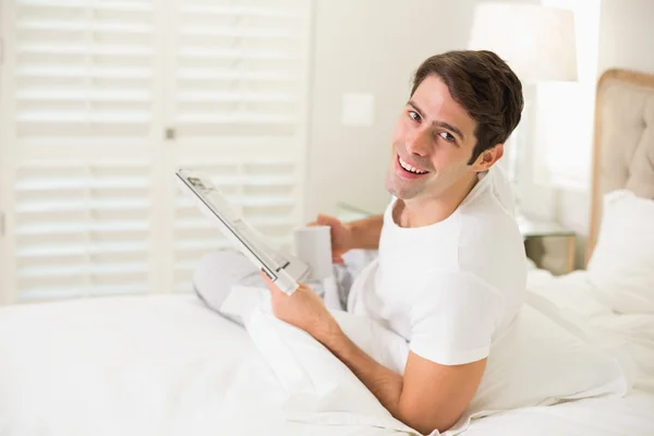 Sorrindo homem tomando café enquanto lia jornal — Fotografia de Stock